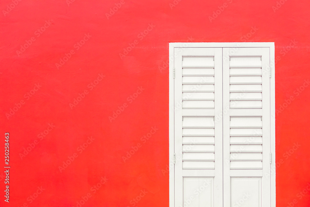 Simple duotone white closed window and bright red wall of building exterior flat facade with space for text Simple duotone white closed window and bright red wall of building exterior flat facade with space for text