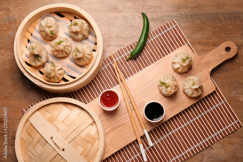 Tasty dumplings with sauces on table