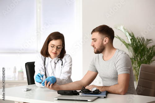 Doctor taking blood sample ...