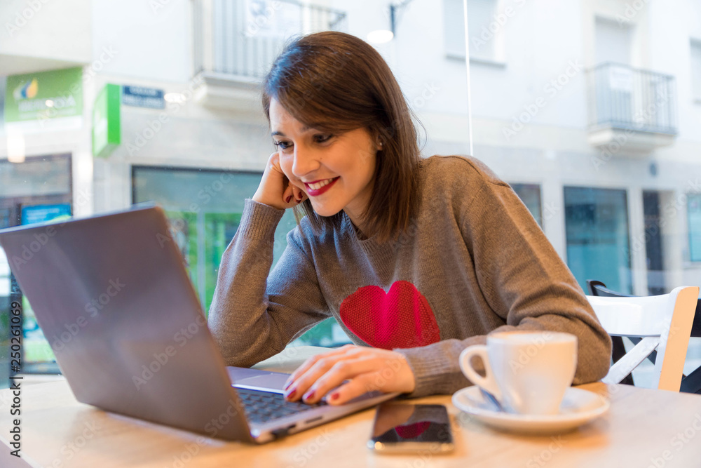 pretty young girl in cafeteria drinking coffee and working with laptop pretty young girl in cafeteria drinking coffee and working with laptop