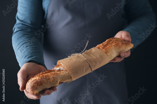 Man with loaf of fresh bread, closeup