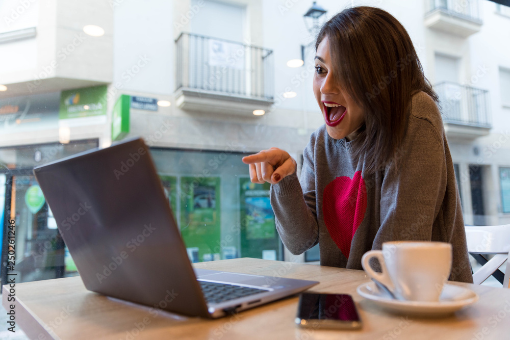 pretty young girl in cafeteria drinking coffee and working with laptop pretty young girl in cafeteria drinking coffee and working with laptop