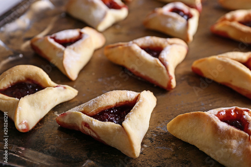 Tasty hamantaschen for Purim holiday on metal tray photo