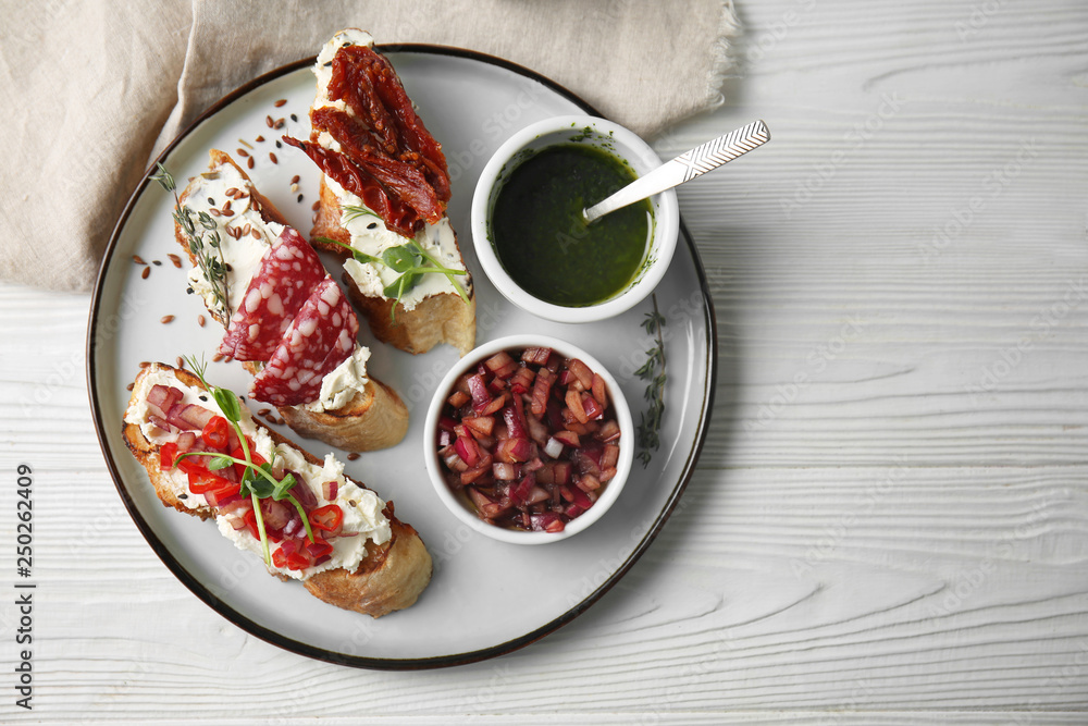 Plate with fresh tasty bruschettas on wooden background Plate with fresh tasty bruschettas on wooden background