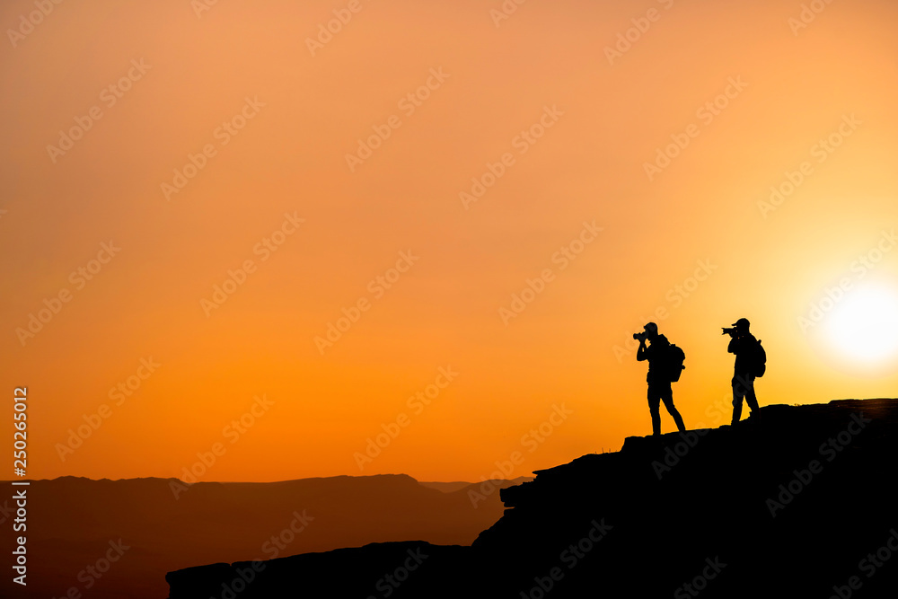 Photographers who shoots a sunset in the mountains