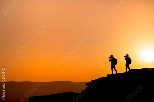 Photographers who shoots a sunset in the mountains