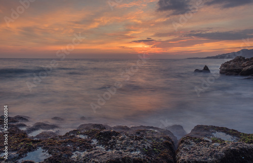 Nerja, Malaga, Andalusi, Spain - January 18, 2019: Nice sunrise with a rich area on Burriana beach, village of Nerja, Spain