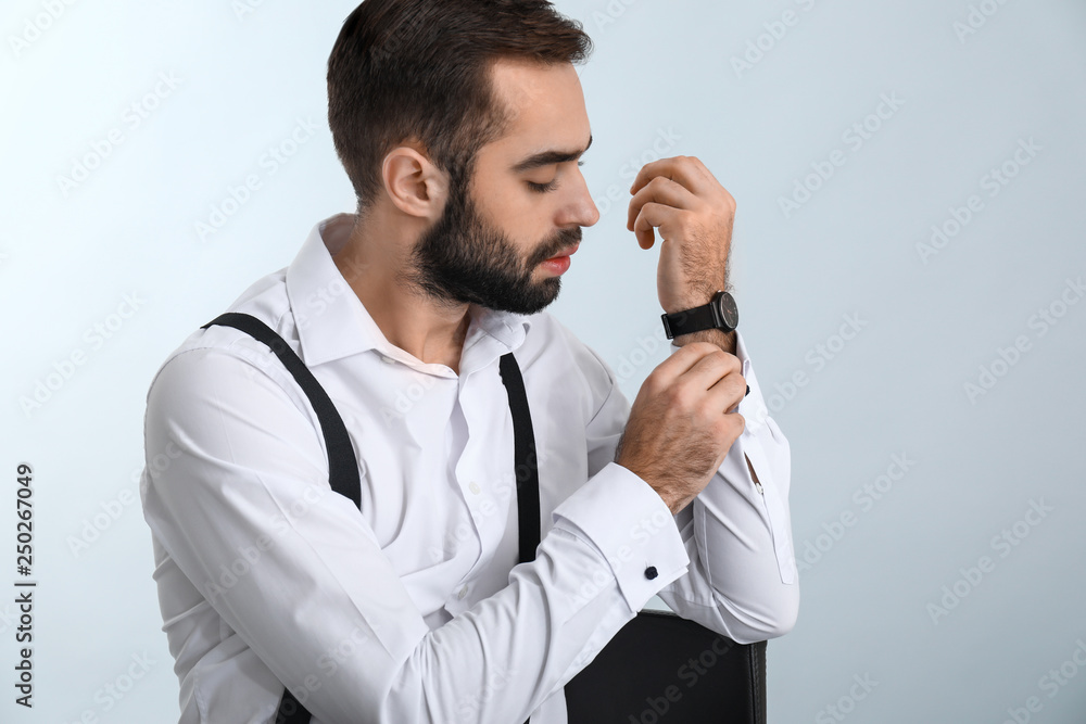Handsome fashionable man in formal clothes against light background Handsome fashionable man in formal clothes against light background