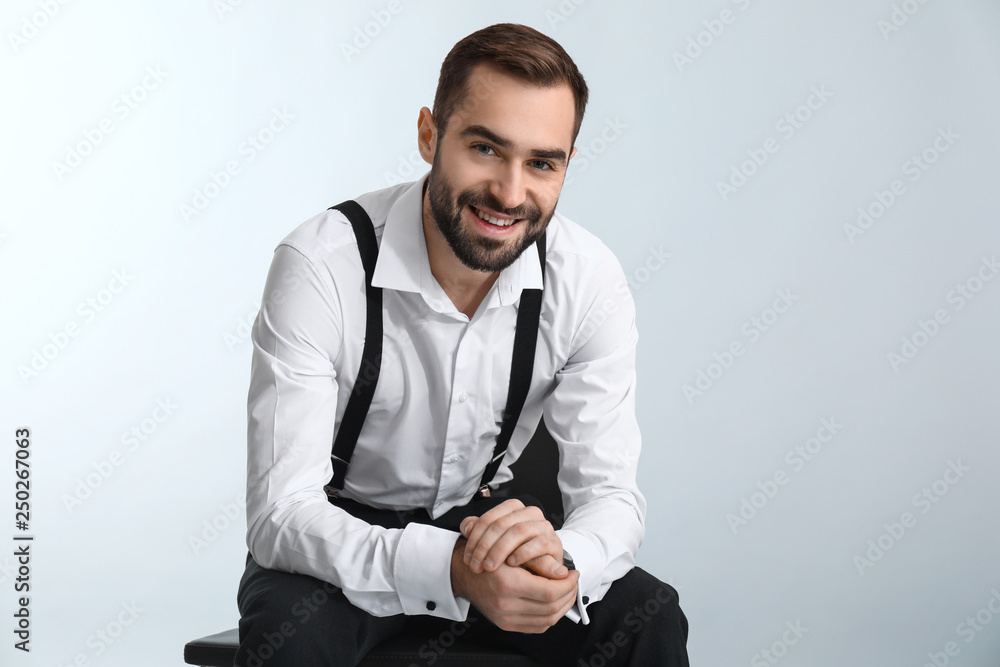 Handsome fashionable man in formal clothes against light background Handsome fashionable man in formal clothes against light background