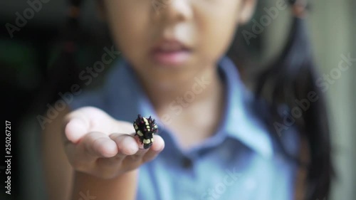 Black caterpillar crawling on girl hand, she playing and happiness, slow motion shot photo