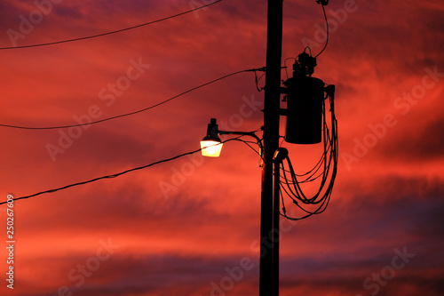 Street light on power pole with sunset sky in background, electricity concept.