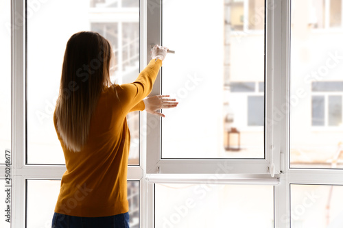 Young woman opening window in flat