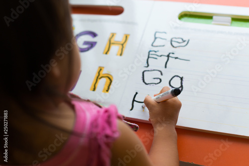 Kid learning how to write the abc's at home.