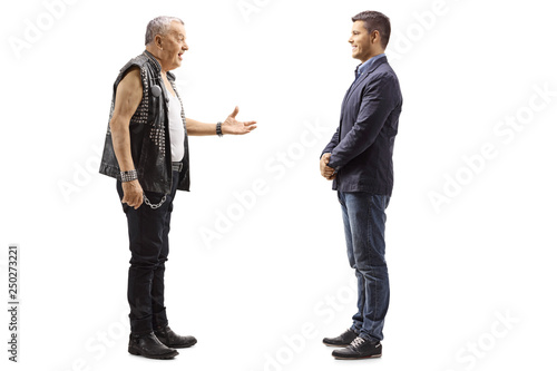 Mature man in a leather vest talking to a young man