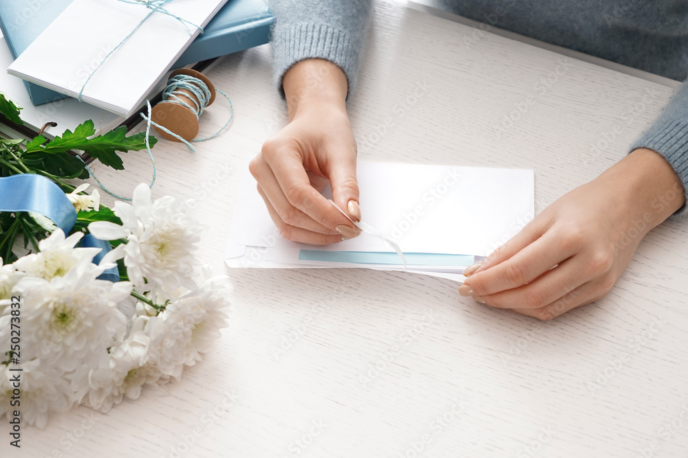 Young woman opening envelope with letter at table Young woman opening envelope with letter at table