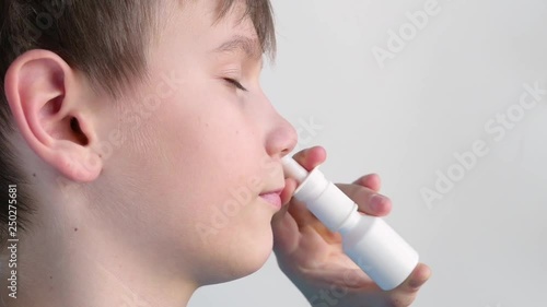 Boy using nasal spray and smiling