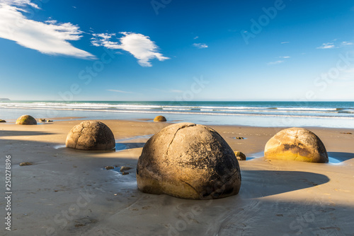 Landmark on the east coast of the South Island, Moeraki Boulders under a dramatic dawn sky.