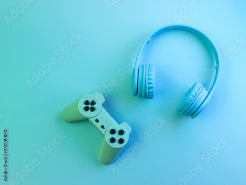 Gamer concept. Headphones and gamepad. Retro wave, neon light, ultraviolet. Top view, minimalism