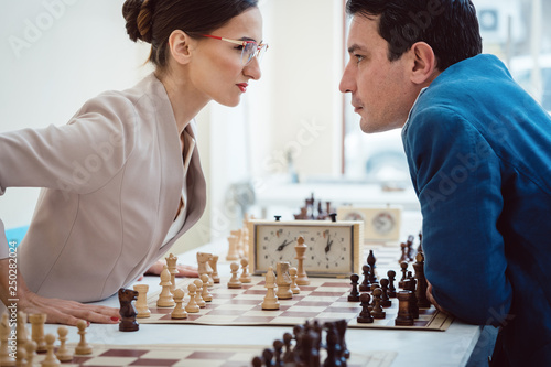 Concept of confrontation, businesspeople playing chess
