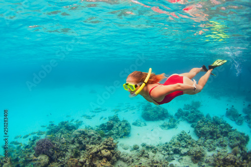 Young woman in snorkeling mask dive underwater with tropical fishes