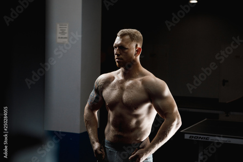 Strong man posing in gym