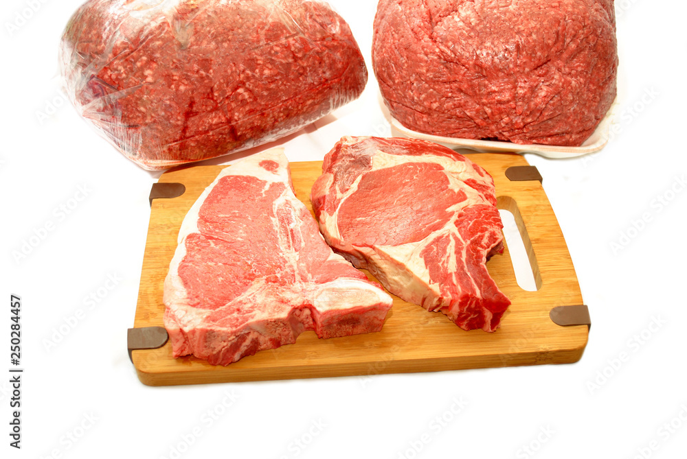 Raw Thick Pork Chops with Ground Beef in the Background Raw Thick Pork Chops with Ground Beef in the Background
