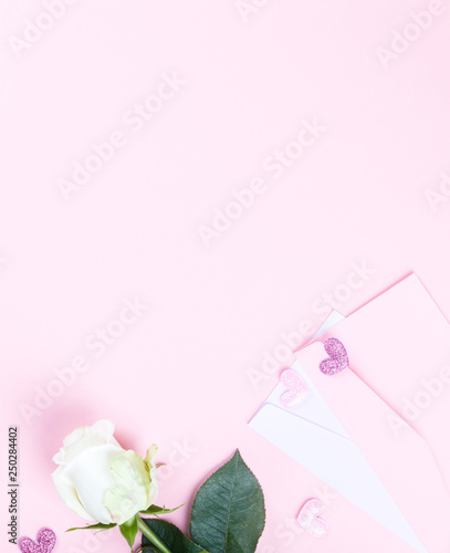 Valentines Day composition. Gift box, white rose flowers, envelope on pastel pink background. Mothers day, Womens Day Holiday concept. Flat lay, top view, copy space