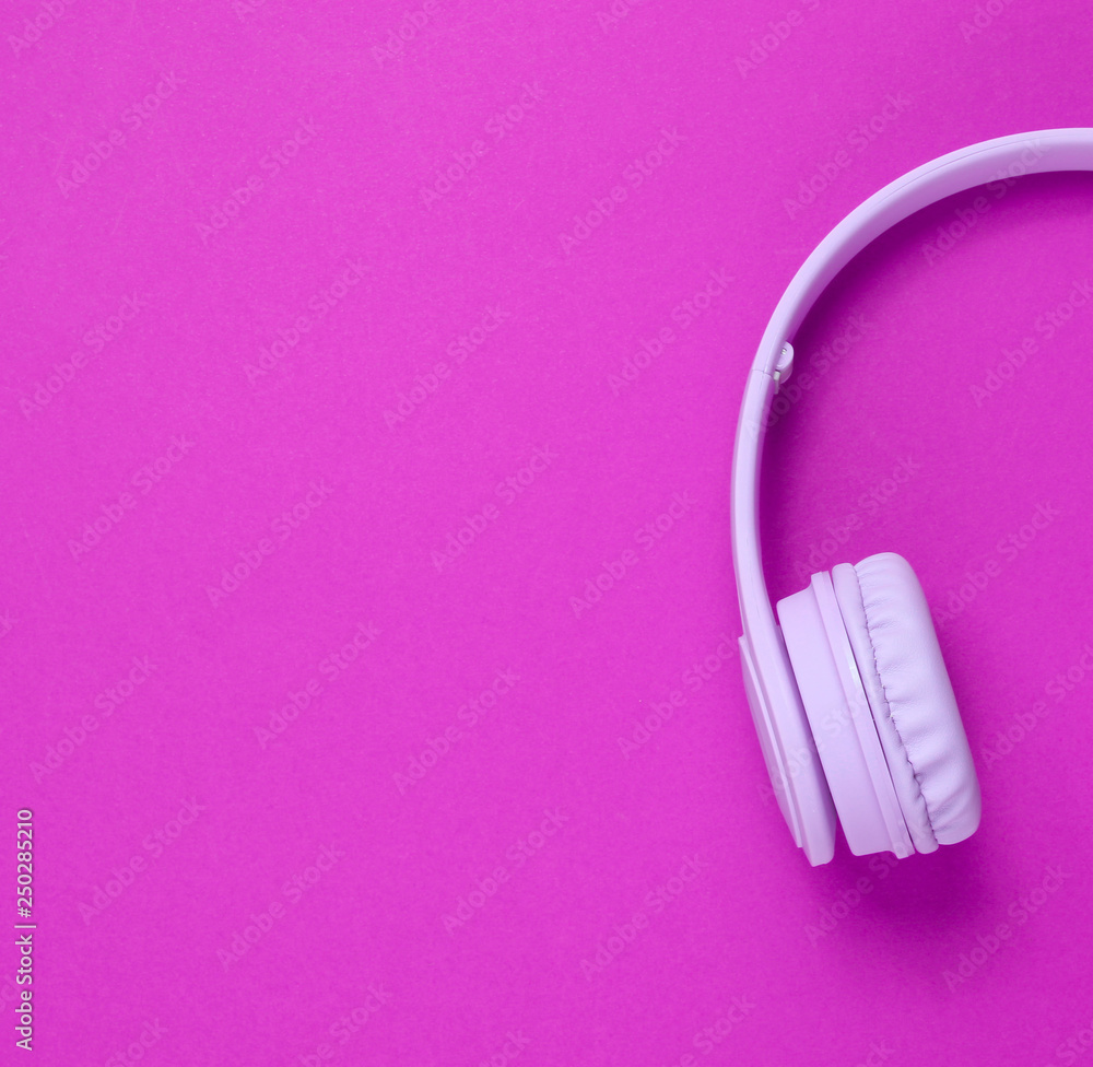 Half of purple headphones on pink background. Top view. Copy space Half of purple headphones on pink background. Top view. Copy space