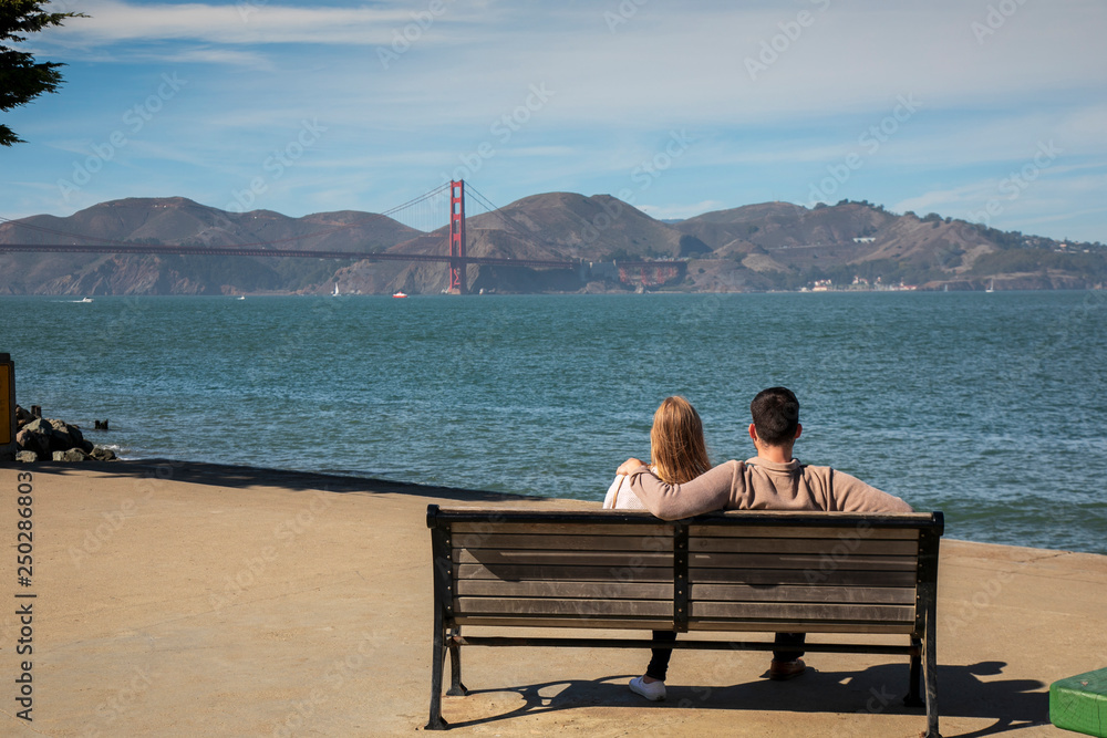 Romantic loving couple having a date in San Francisco, California, USA. Golden gate bridge in the background