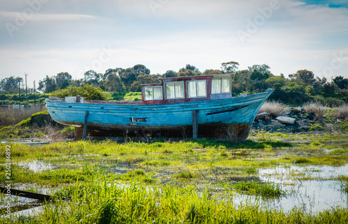 An abandoned and ruined blue boat. 