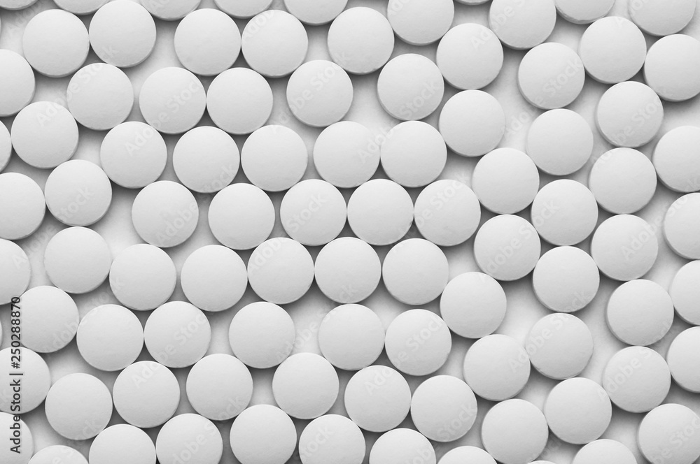 Small white pills on a white background close-up. Small white pills on a white background close-up.