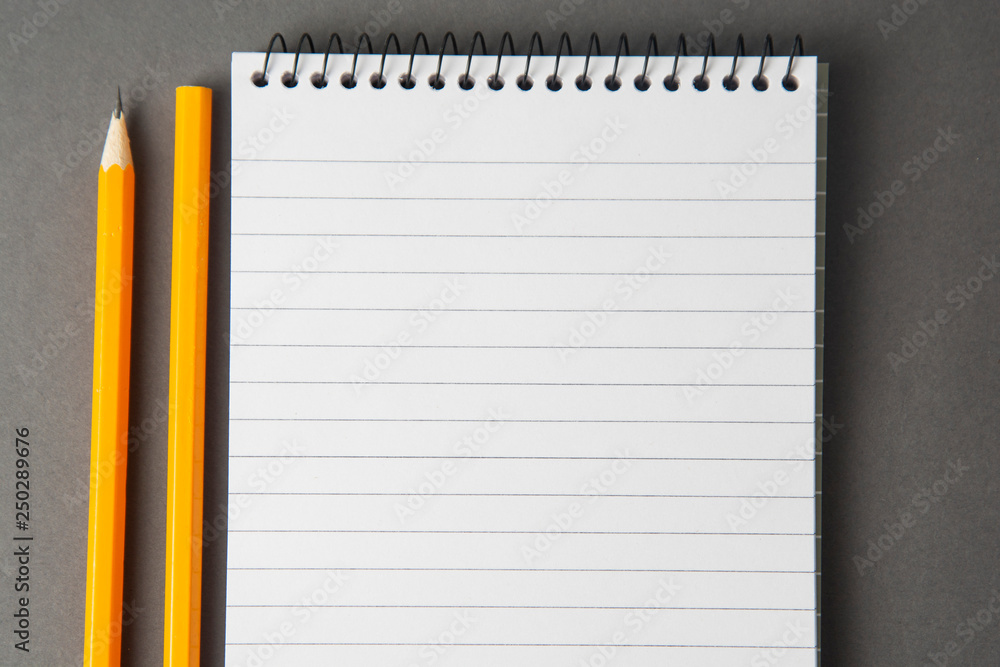 Notepad or notebook with pencil on gray background. Concept for education, business with copy space. Mock up. Notepad or notebook with pencil on gray background. Concept for education, business with copy space. Mock up.