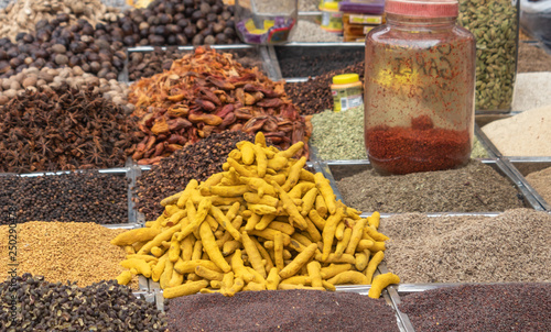 Dried turmeric sticks in focus and other spices  on display in a shop at the biggest wholesale spice market of Goa. Mapusa market  photo