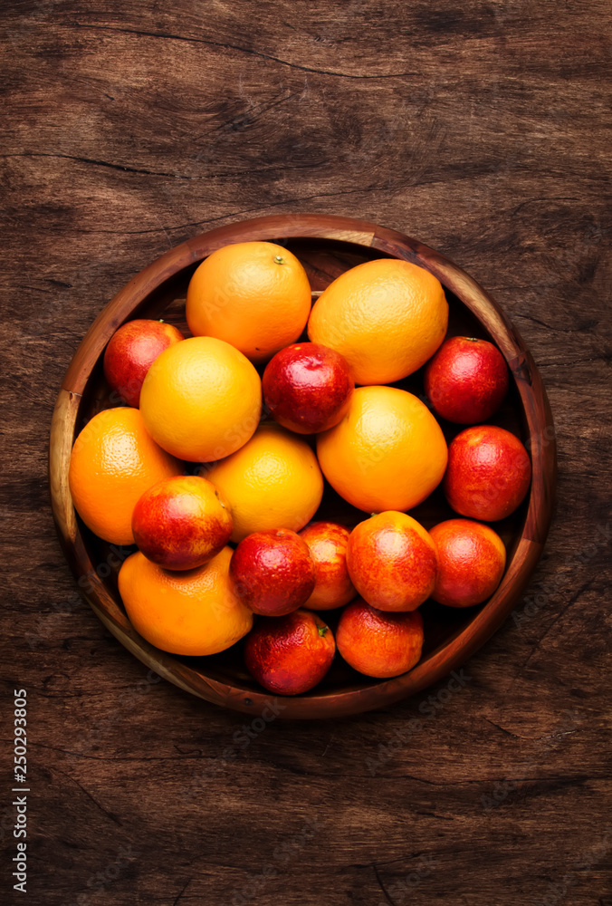Bright fruits in large tray: oranges, lemons, mango in assortment. View from above Bright fruits in large tray: oranges, lemons, mango in assortment. View from above
