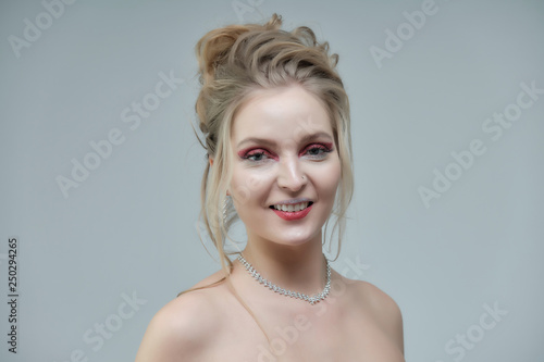 Smiling girl with clean skin  natural make-up and white teeth on a gray background in a beauty salon