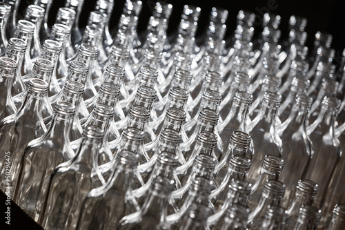 Slika na platnu Many bottles on conveyor belt in glass factory