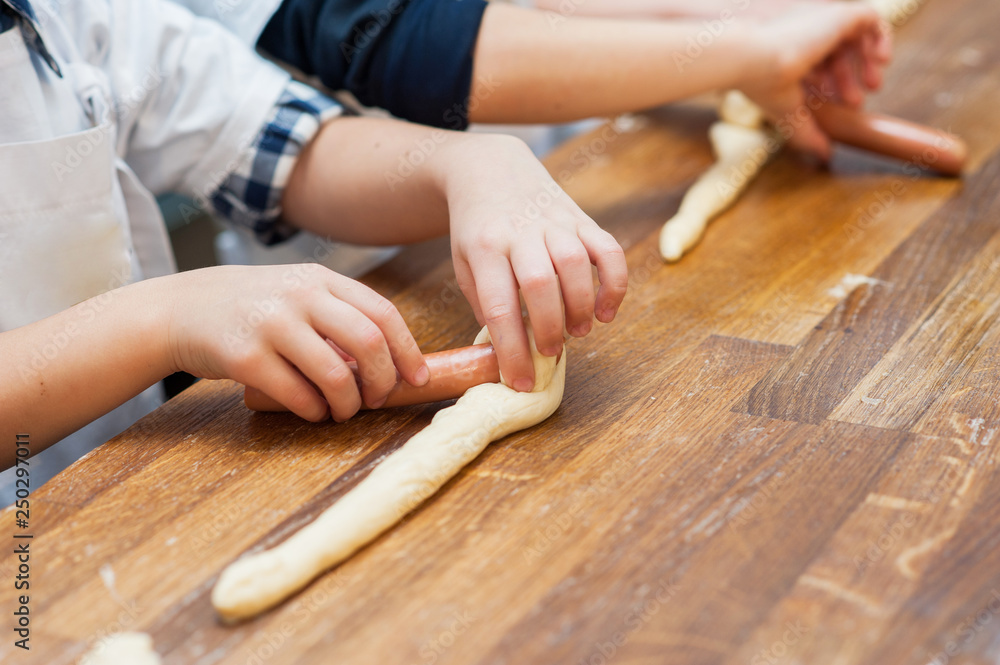 Young children make hot dog. Hands closeup Young children make hot dog. Hands closeup