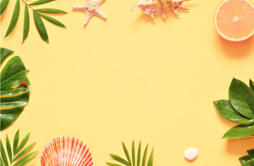 Tropical background. Palm trees branches with starfish and seashell on yellow background. Travel.