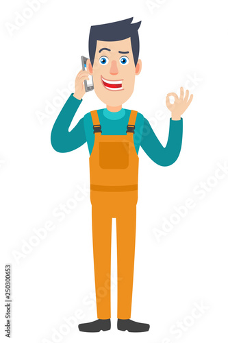 Worker talking on mobile phone and showing a okay hand sign