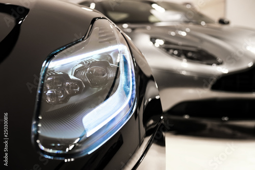 Headlights of sport car at dealer showroom photo
