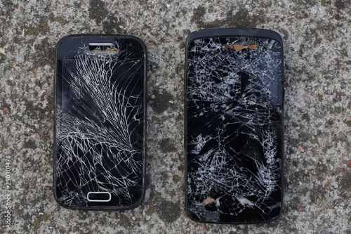 Broken, destroyed, ruined modern mobile smartphone, cell phone, mobile phone, phone. Broken, cracked screen and damages. Device destroyed. Cell phone crashed and scratch. Smash gadget, need repair.