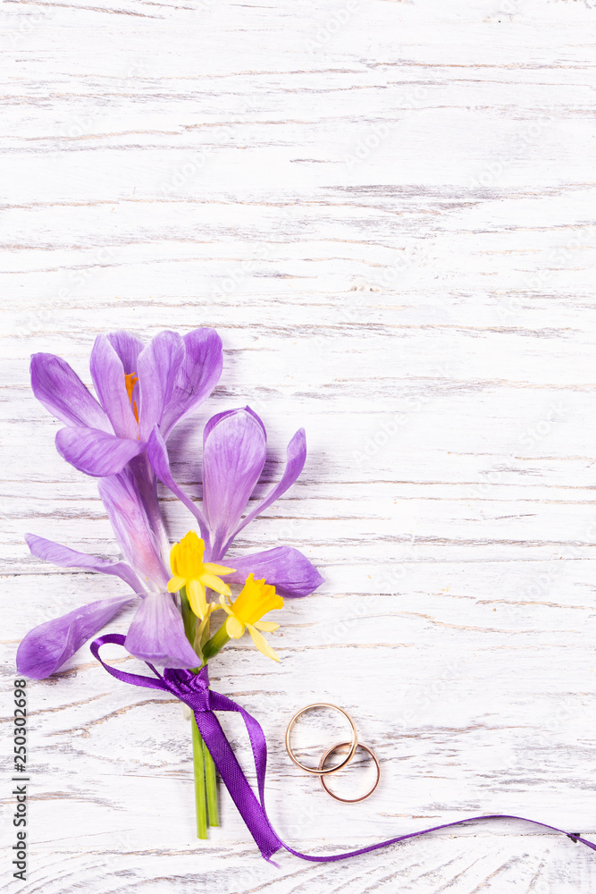 Wedding concept with spring flowers and two golden rings
