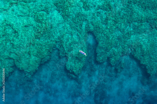 aerial of paddler on reef