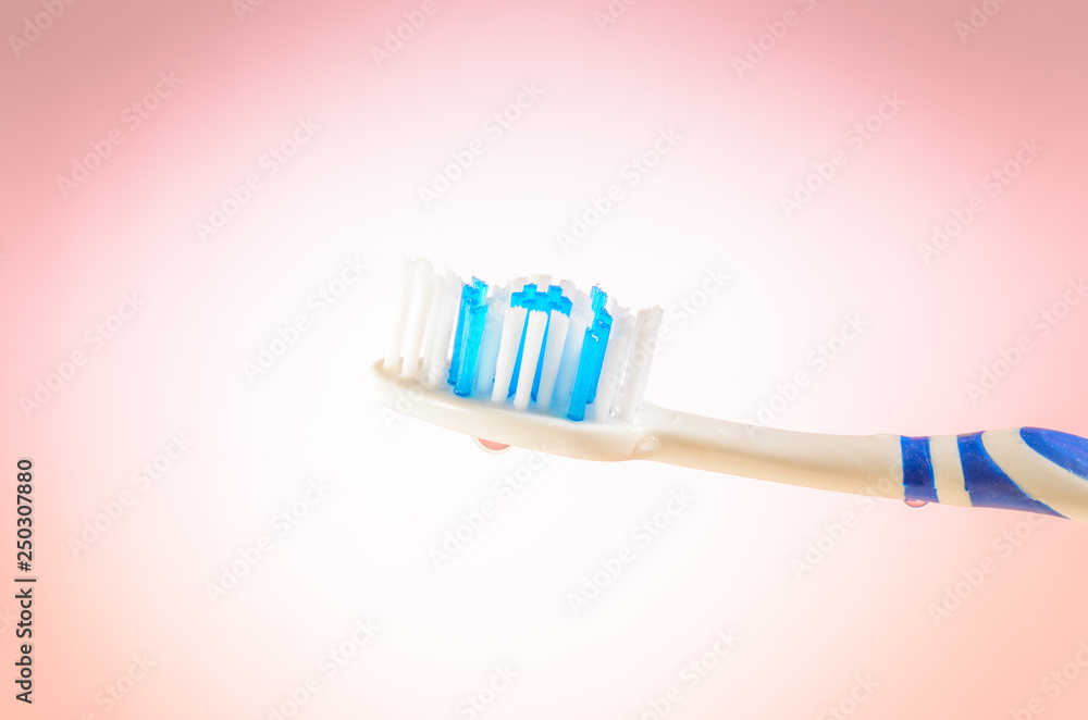 damp toothbrush on a pink background, close up damp toothbrush on a pink background, close up