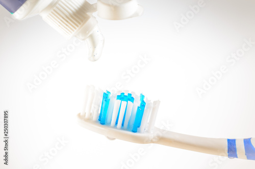 Toothpaste squeezed from tube onto brush on a white background  close up