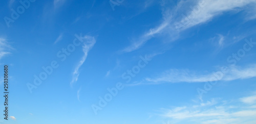 Light clouds in blue sky. Wide photo.