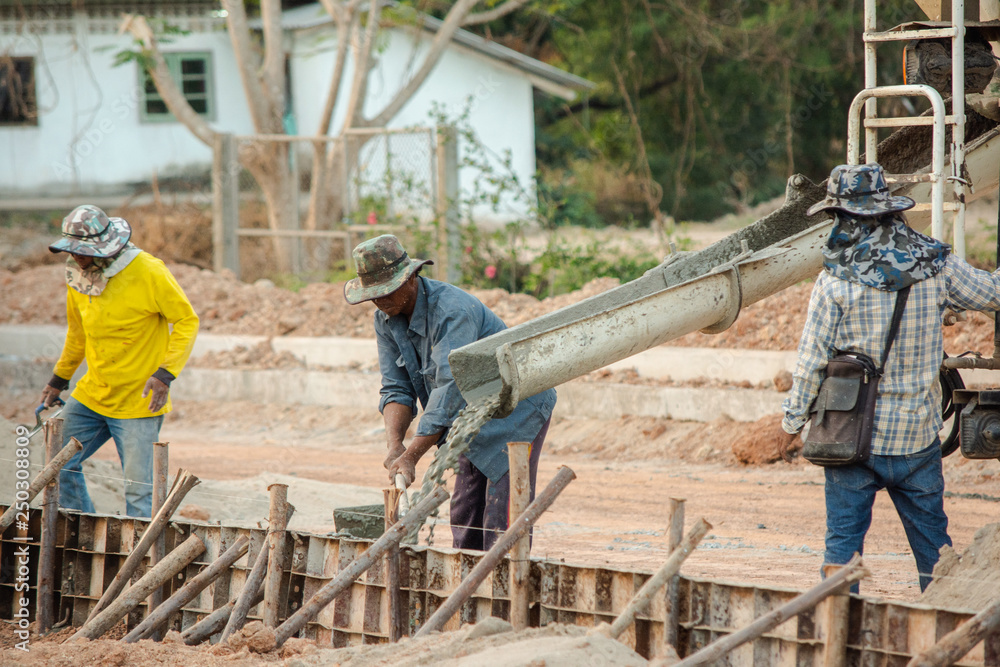 NAKHON PHANOM, THAILAND - DEC 24, 2018 : Concrete mixer truck. Workers are pouring concrete in site building construction NAKHON PHANOM, THAILAND - DEC 24, 2018 : Concrete mixer truck. Workers are pouring concrete in site building construction