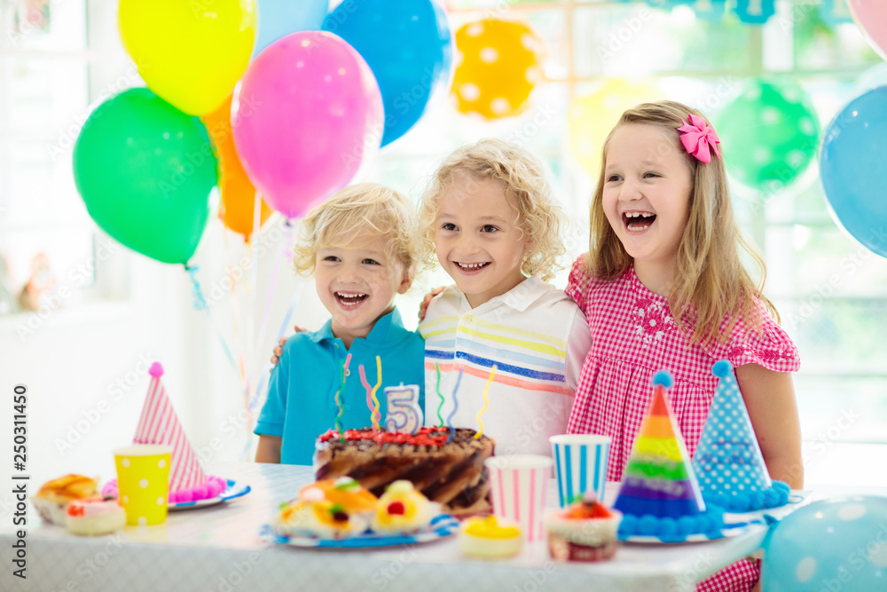 Kids birthday party. Child blowing out cake candle Kids birthday party. Child blowing out cake candle
