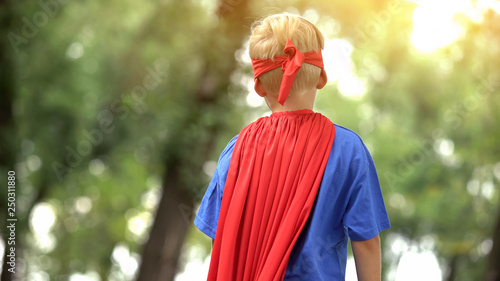 Back view of boy in superman costume, dreamy child, recreational activity