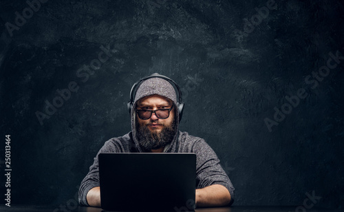 A hacker sits behind a lapt...